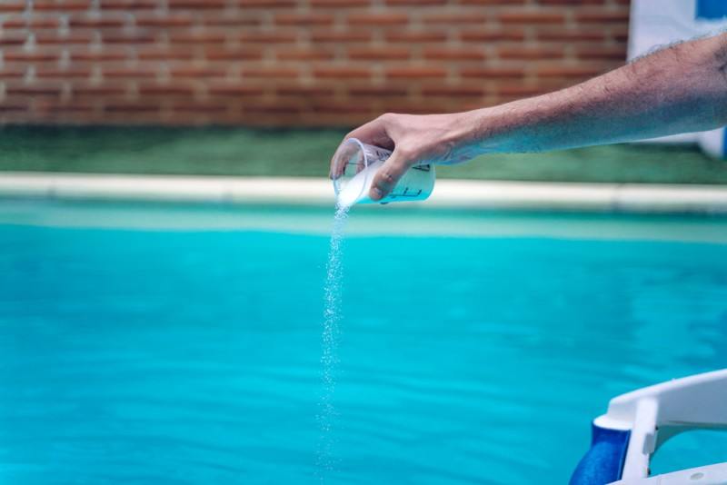 agregando cloro a la piscina
